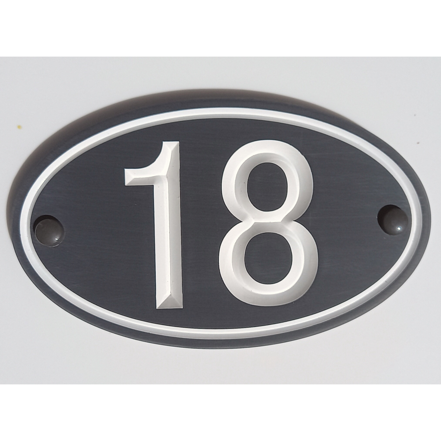 Grey Oval Corian Sign white font